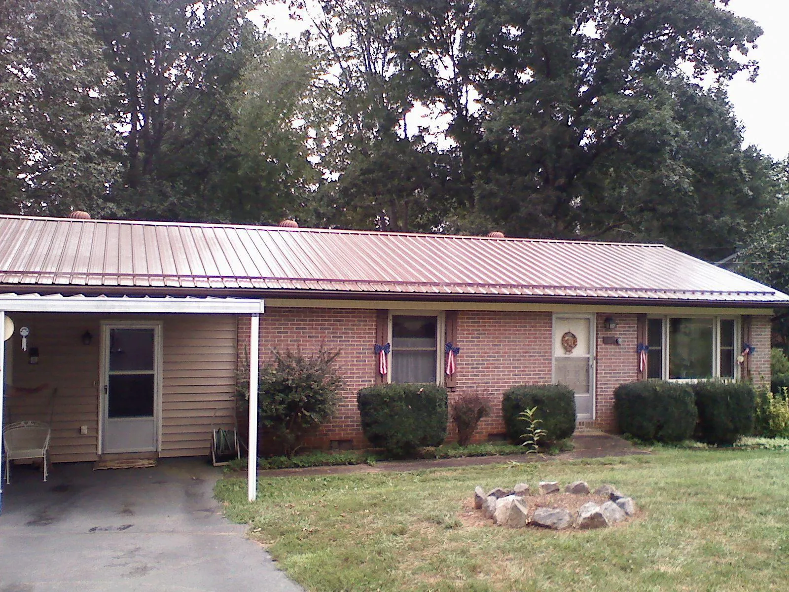 Bronze metal roof and carport on a brick ranch home — Roof Repair work by our crew in Hilo
